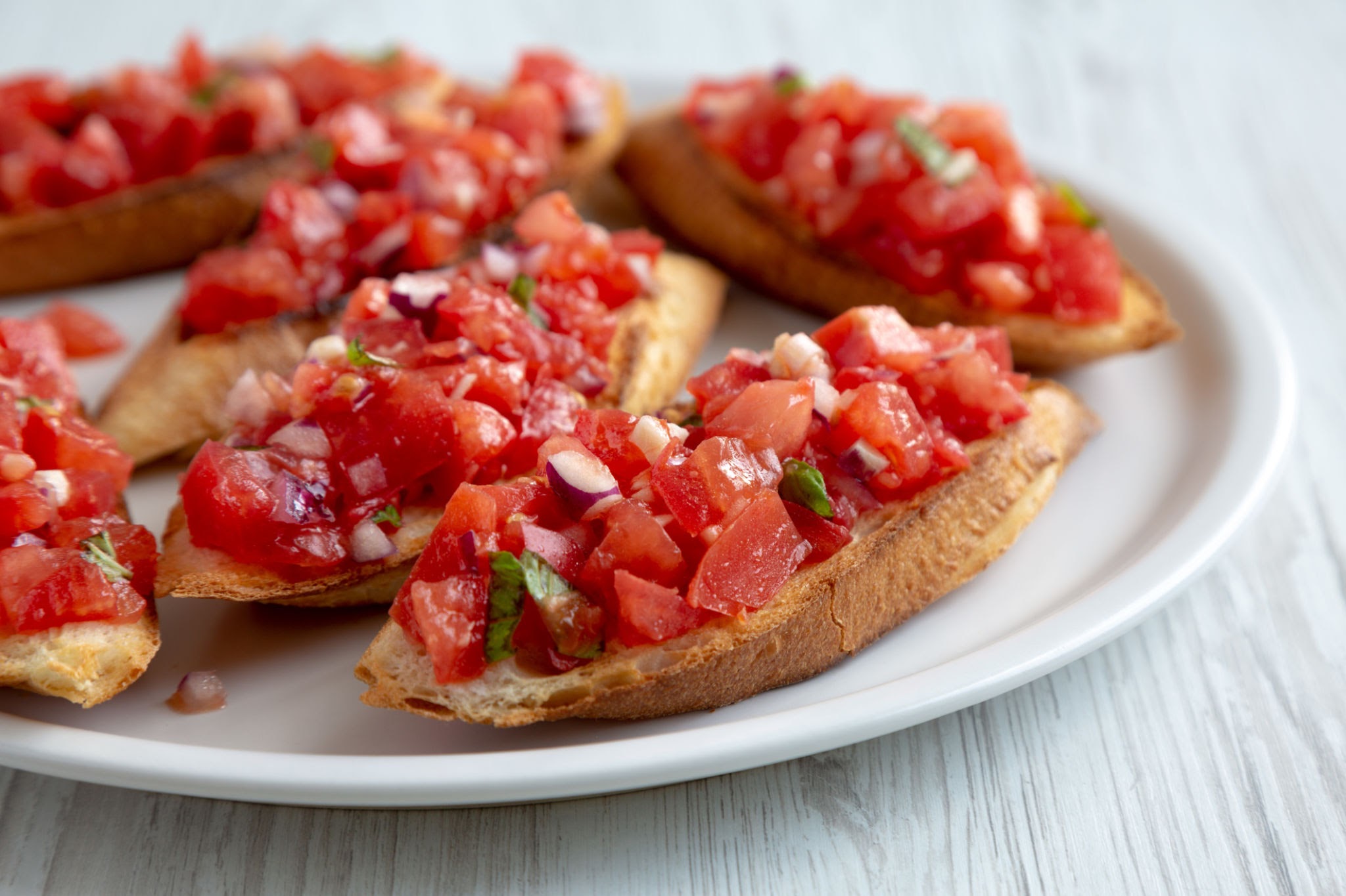 Home homemade italian tomato bruschetta with basil on a plate, side view. close up.